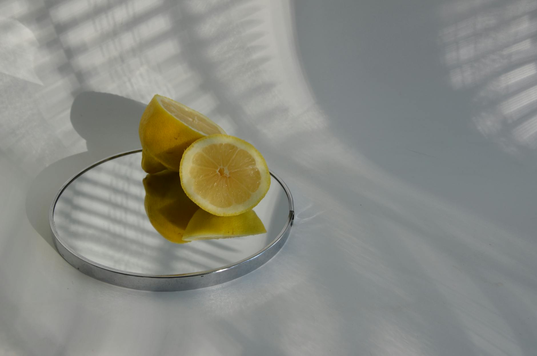 Limoni affettati su uno specchio con ombre delicate, come il piacere che ritorna gradualmente nel tempo.