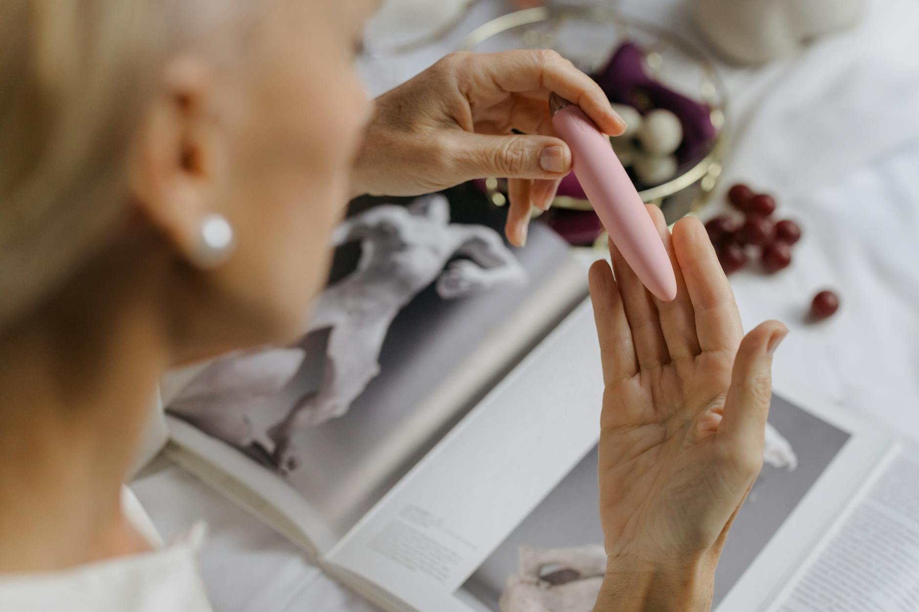 Woman holding colorful clitoral vibrators, representing tools for sensation recovery after medication changes