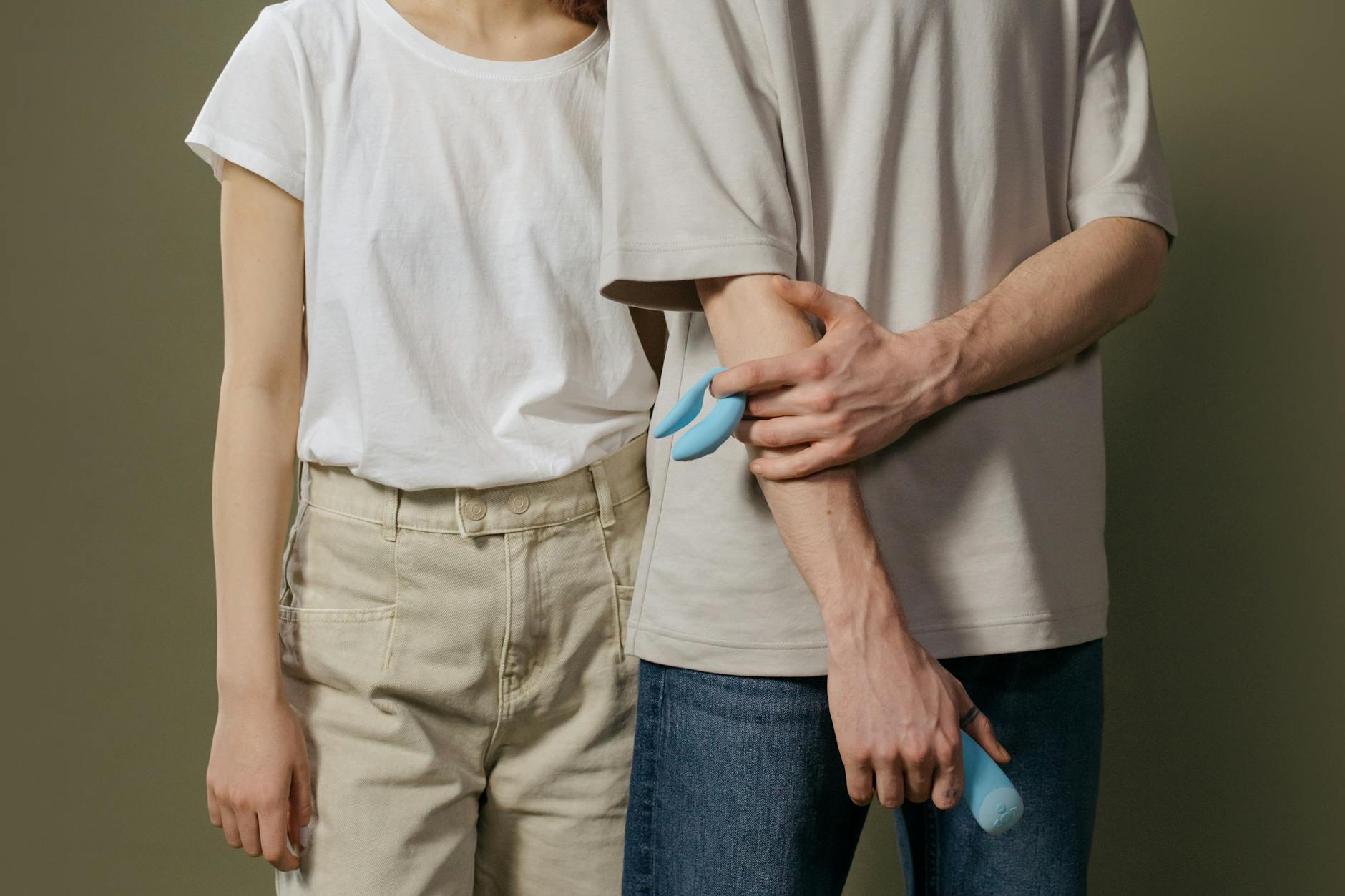 A couple standing together indoors with a modern clitoral vibrator, symbolizing shared pleasure and emotional intimacy