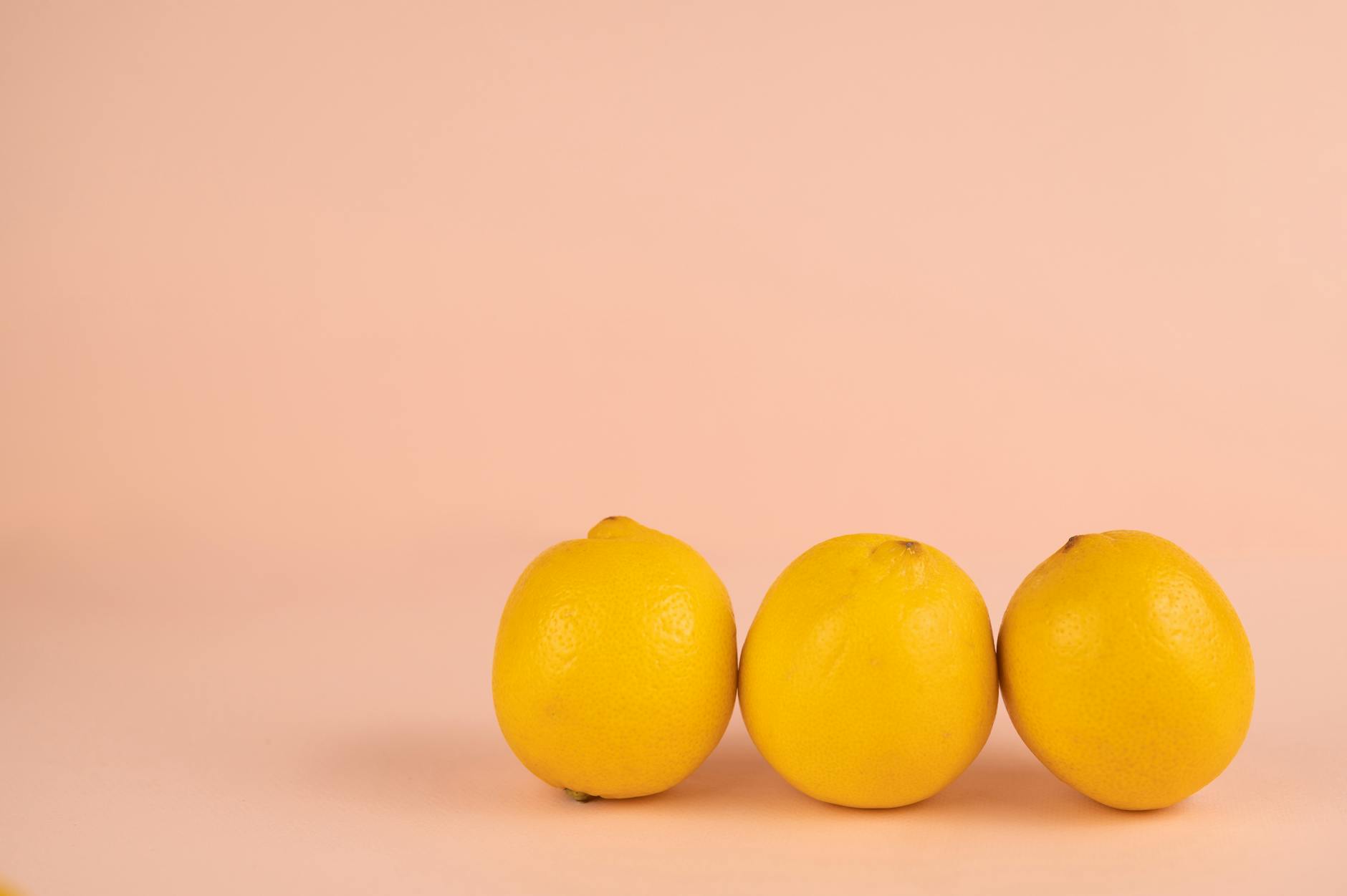 Bright ripe lemons arranged on a pastel background, symbolizing fresh pleasure
